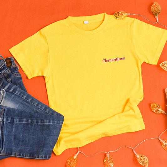 Yellow t-shirt with 'Clementines' text and blue shorts on an orange background