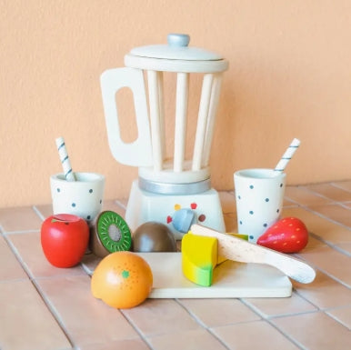 Children's toy blender set with fruits and cups on a tiled floor