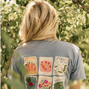 Person wearing a t-shirt with colorful patch designs in an outdoor setting