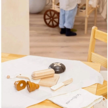 Wooden toys on a table with a white cloth, blurred background of a room.