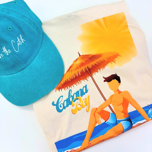 Turquoise cap and 'Cubana Boy' beach towel with a tropical design on a white background