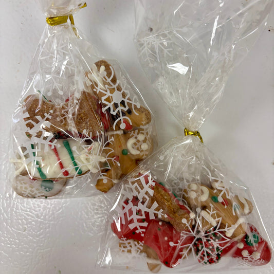 Two clear plastic bags containing Holiday decorated Dog Treats on a white surface.