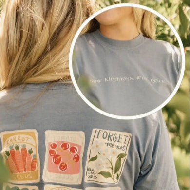 Person wearing a t-shirt with various patches and a close-up of text on the shirt.