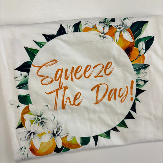 Decorative pillow with 'Squeeze The Day!' text and orange design on a white background