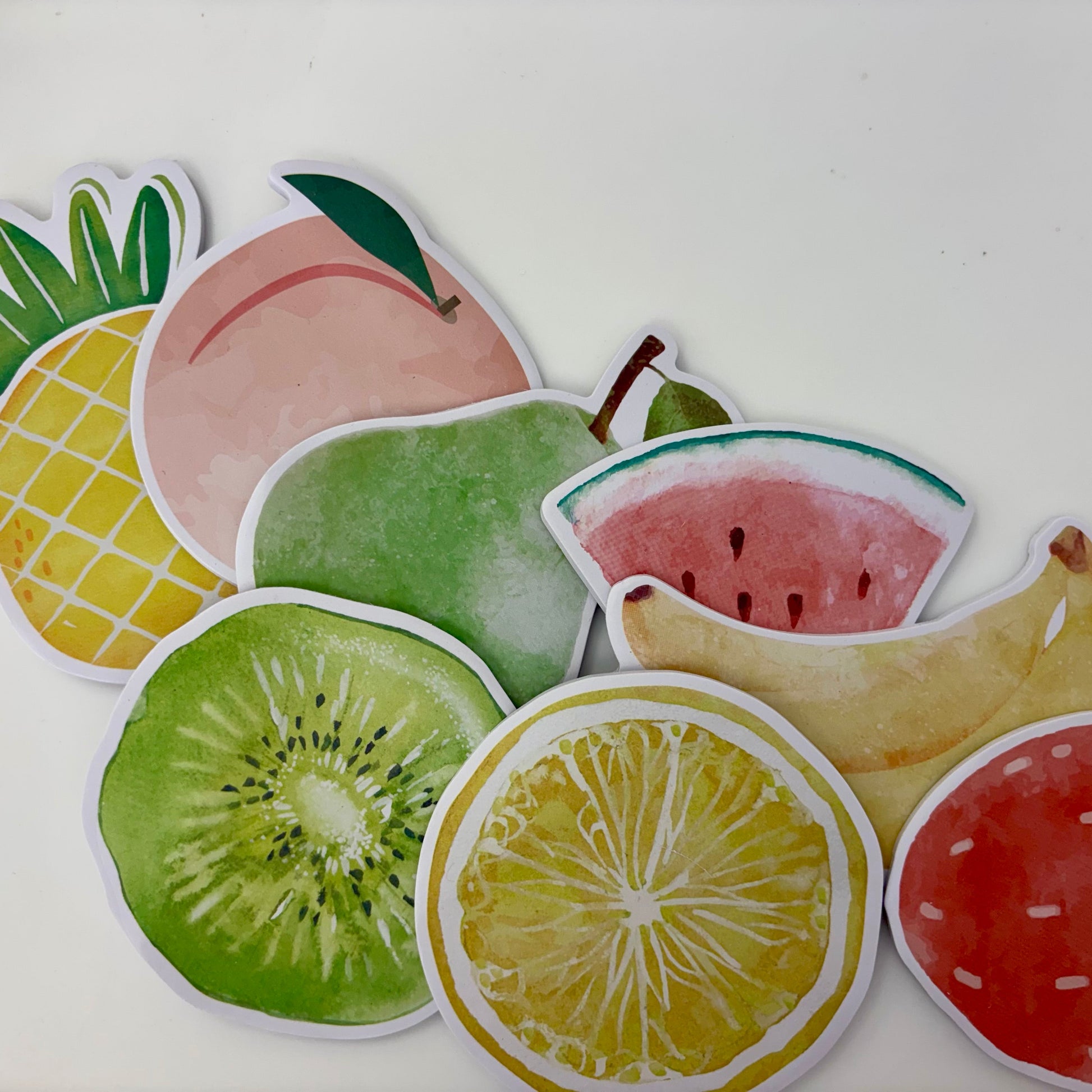 Colorful fruit-shaped stickers on a white background