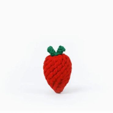 Red strawberry-shaped toy with green leaves on a white background