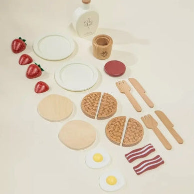 Play food set including waffles, eggs, bacon, and utensils on a light background