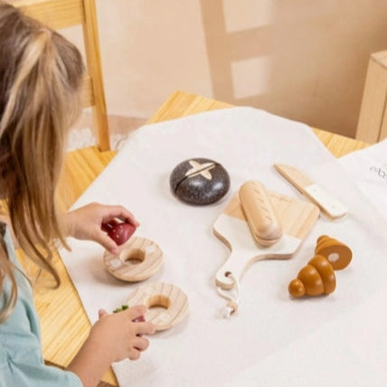 Child playing with wooden toys on a table