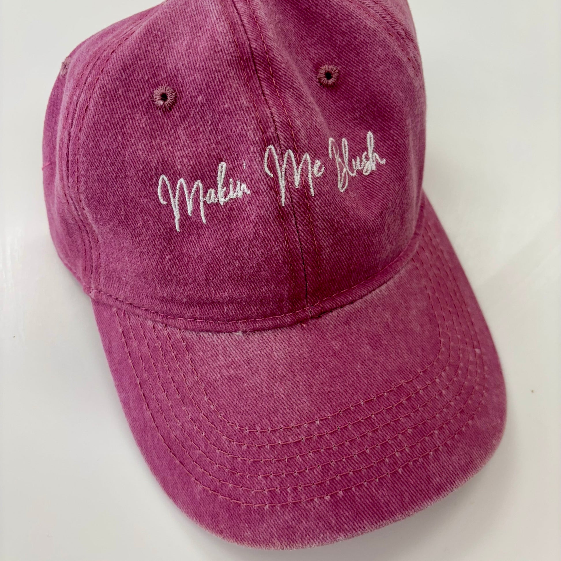 Purple cap with 'Makin' Me Flush' text on a white background