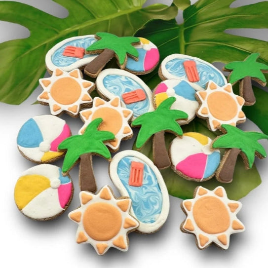 Decorative dog cookies with summer-themed designs on a leafy background
