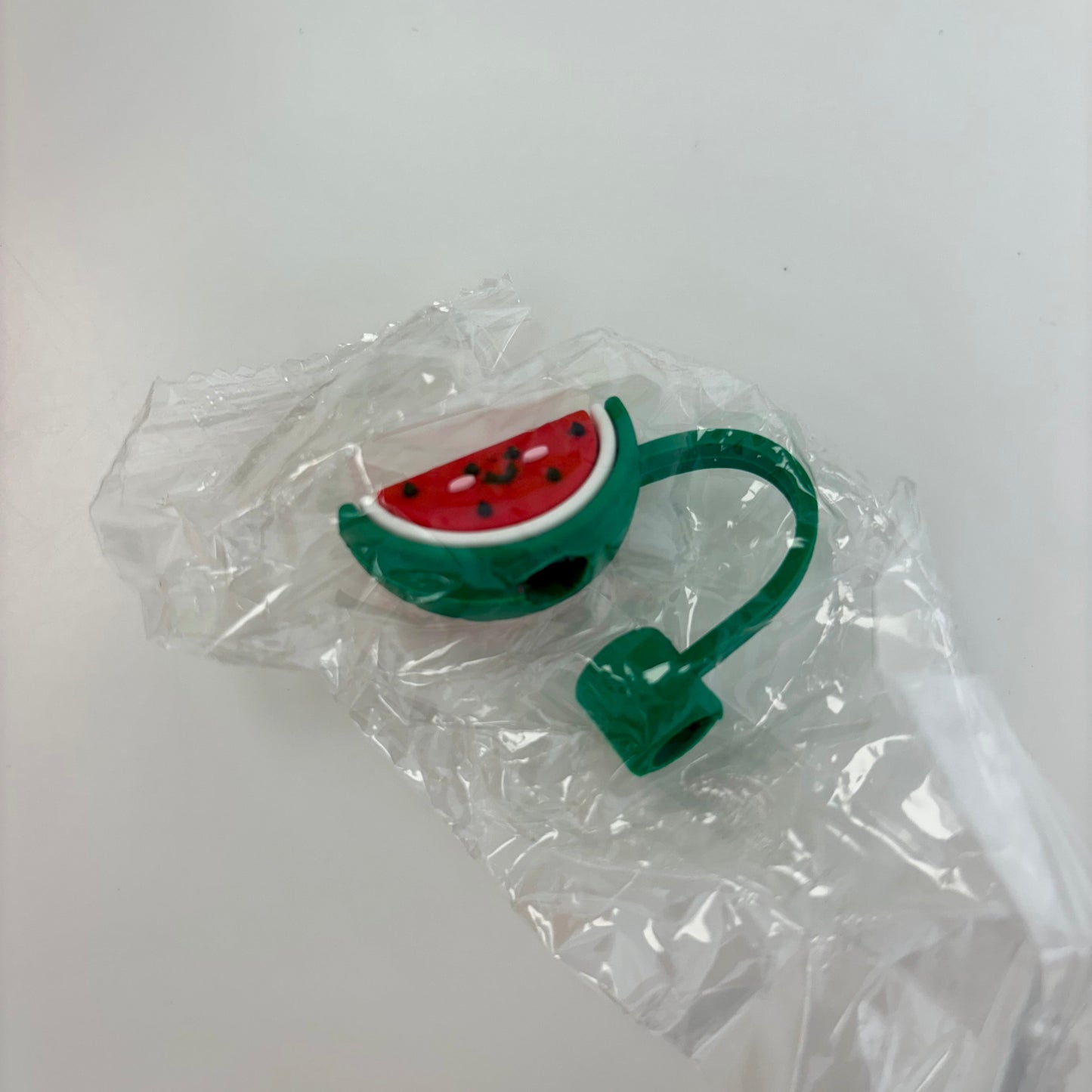 Watermelon-themed straw topper with a green stem on a white background
