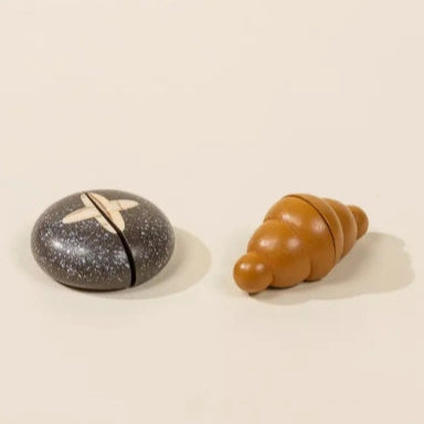 Two small objects, one speckled black and gray and the other brown, on a beige background.