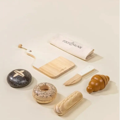 Set of wooden toy food items and utensils on a light surface with 'coco&luke' branding.