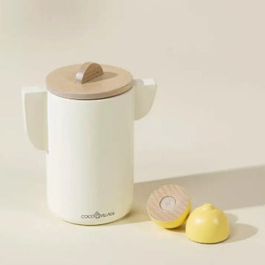 White ceramic mug with wooden lid and accessories on a light background