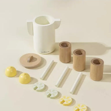 Set of kitchen items including a white pitcher, wooden cups, and yellow lemons on a light background