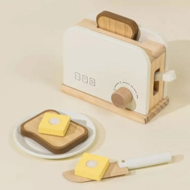 Wooden toaster with a slice of bread and butter on a beige background