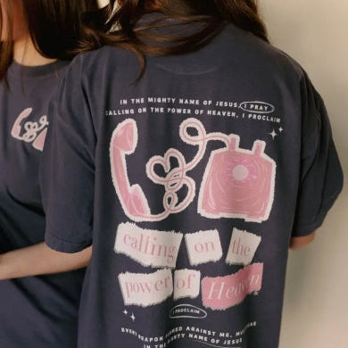 Two people wearing navy blue t-shirts with pink graphics and text.
