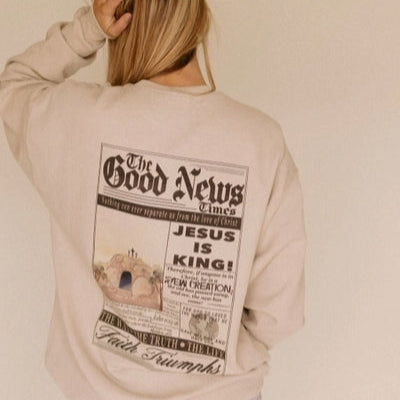 Person wearing a beige sweatshirt with a graphic design on the back, featuring text and an illustration.