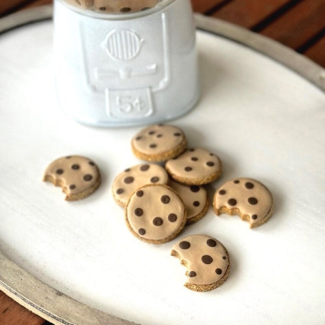 Chocolate chip dog cookies on a white plate with a robot-shaped container in the background.