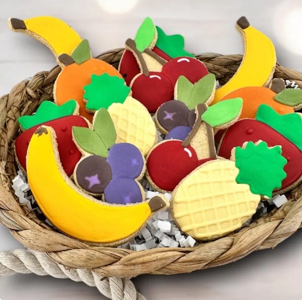 Colorful fruit-shaped dog cookies in a woven basket