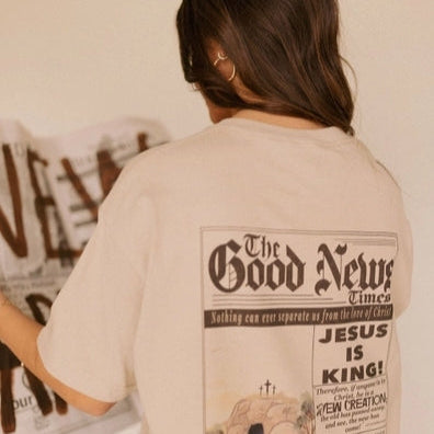Person wearing a t-shirt with 'The Good News' newspaper design.