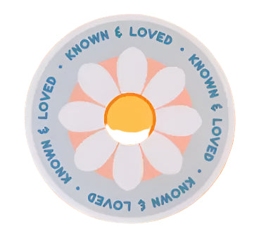 Circular sticker with a white flower design and 'Known & Loved' text on an orange background