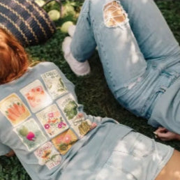 Two people sitting on grass with a focus on their legs and feet.