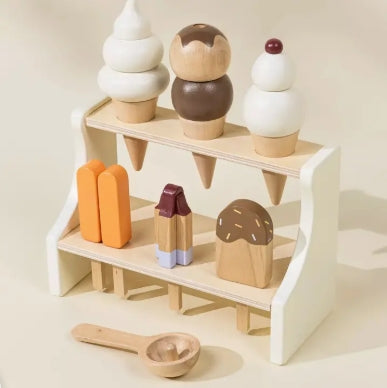 Wooden toy ice cream set on a white shelf with a wooden spoon on a light beige background