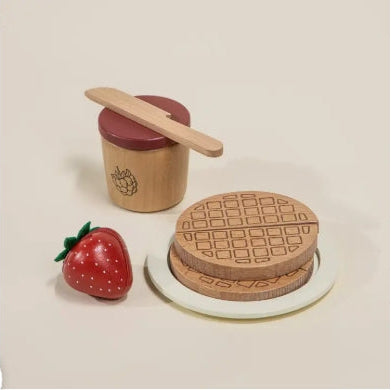 Wooden toy set with a waffle, strawberry, and container on a beige background