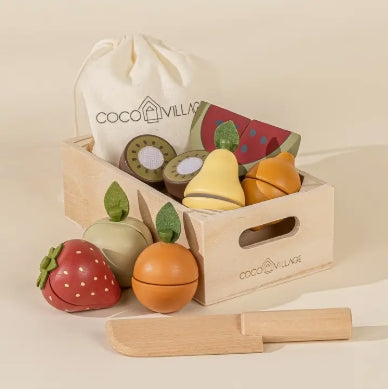 Set of wooden toy fruits and vegetables with a carrying bag labeled 'Coco Village' on a beige background.