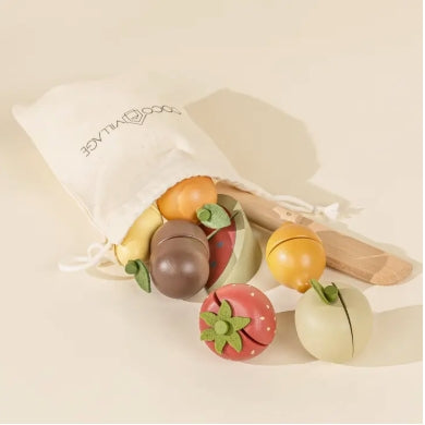Set of colorful wooden fruit toys with a white drawstring bag on a beige background
